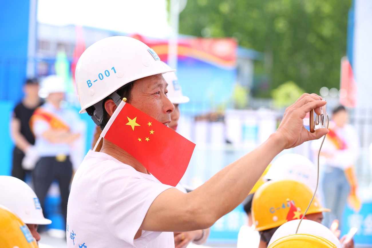 4月24日,全国农村留守儿童关爱保护“百场宣讲进工地”活动在中建二局北京某工地正式启动。图为务工人员在拍摄中建二局施工现场的安全展示图牌。李旭 摄.jpg 4月24日,全国农村留守儿童关爱保护“百场宣讲进工地”活动在中建二局北京某工地正式启动。图为务工人员在拍摄中建二局施工现场的安全展示图牌。李旭 摄.jpg