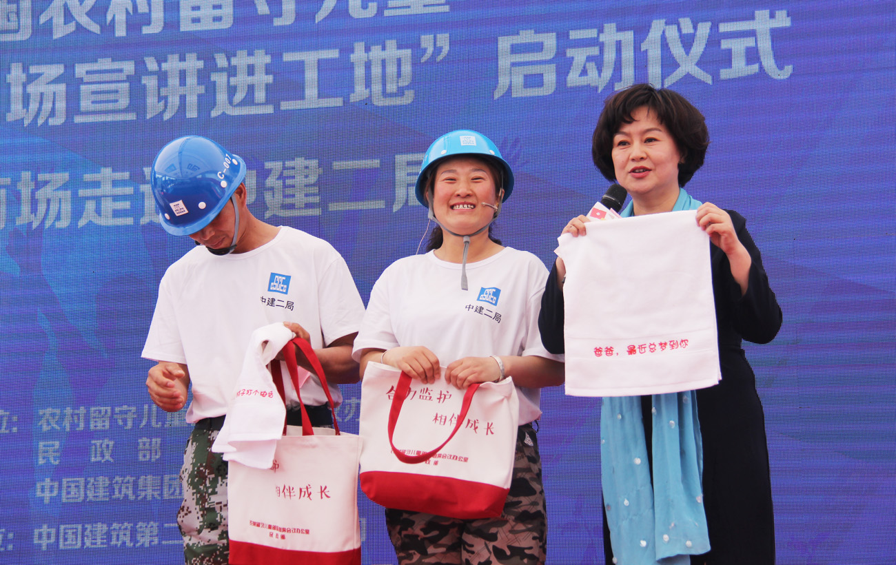 4月24日，全国农村留守儿童关爱保护“百场宣讲进工地”活动在中建二局北京某工地正式启动。图为鞠萍在采访农民工代表，展示相关安全用品 肖永鸿摄.jpg